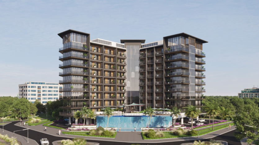 Il Floarea Grande è un moderno edificio a più piani con ampie vetrate, circondato da una vegetazione lussureggiante e da palme. Una piscina blu brillante scintilla di fronte, mentre alcune auto girano intorno alla rotatoria sotto il cielo azzurro.