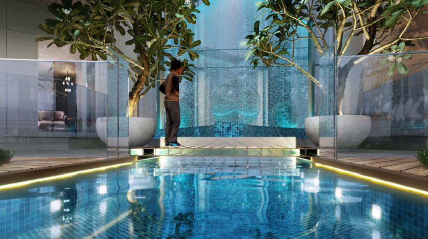 Una persona si trova su una stretta passerella sopra una piscina blu scintillante, circondata da pareti di vetro. Grandi piante di Floarea Grande in vaso incorniciano la scena, con una cascata sullo sfondo che crea un'atmosfera tranquilla.