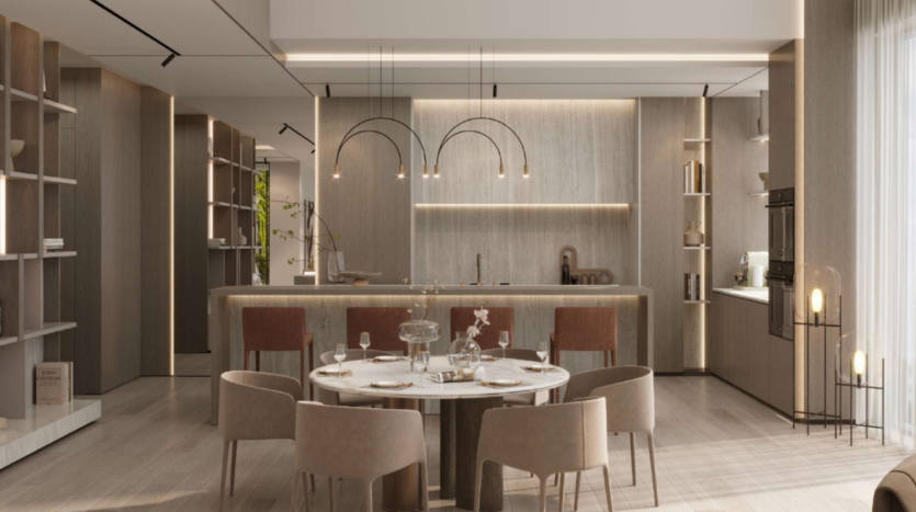 Una cucina e una zona pranzo moderne con un tavolo rotondo in marmo circondato da sedie beige e color ruggine. La cucina è dotata di armadietti in legno, illuminazione a sospensione e un'ampia isola. Gli scaffali alti e le luci soffuse creano un'atmosfera accogliente.