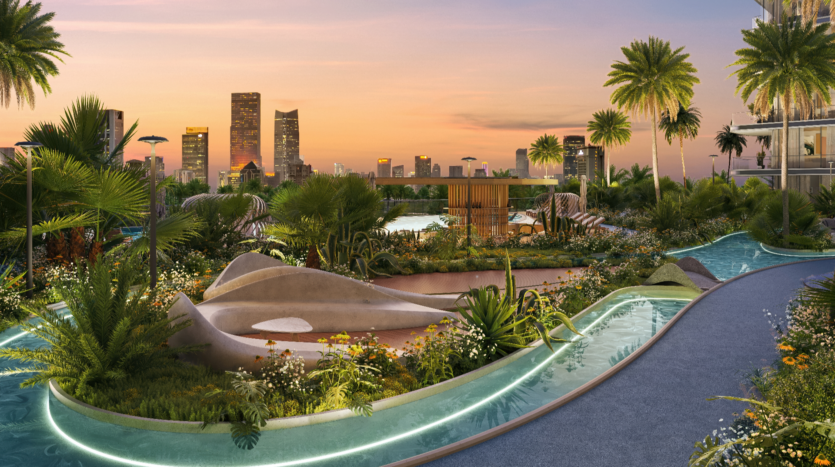 A lush rooftop garden, reminiscent of a Verano getaway, includes a winding path, tropical plants and a flowing water feature. The silhouette of the skyscrapers stands out against a sunset sky, creating a serene and picturesque urban oasis.