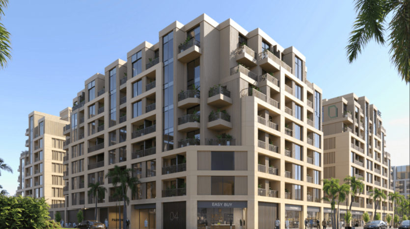 Arisha Terraces è un moderno complesso residenziale con ampie finestre e balconi, circondato da palme. Al piano terra si trovano negozi con insegne accattivanti, il tutto sullo sfondo di un cielo azzurro e limpido.