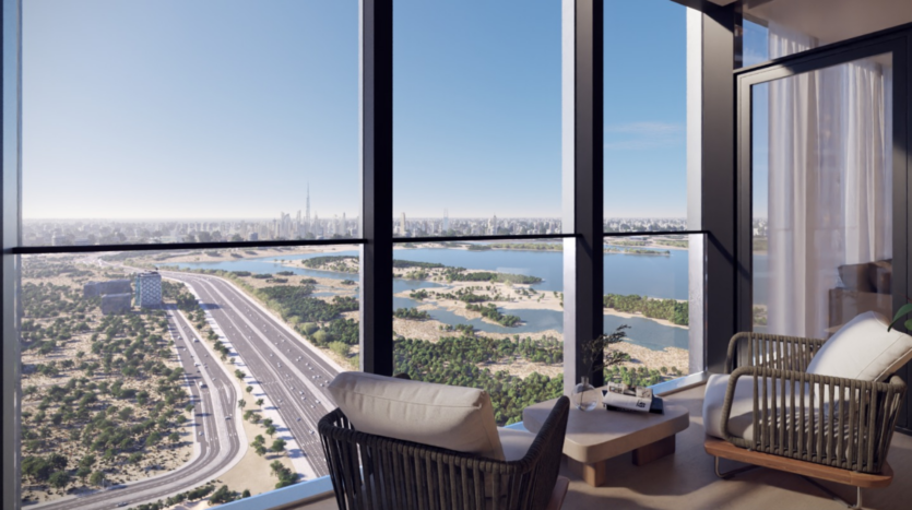 Il balcone di un moderno appartamento di un grattacielo di Sobha One è dotato di due sedie e un tavolino e offre una vista pittoresca sul verde lussureggiante, sulle autostrade tortuose, sui laghi sereni e sullo skyline della città in lontananza sotto un cielo azzurro e limpido.