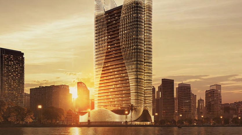 The Binghatti Skyhall, a futuristic skyscraper with an undulating design, rises against a sunset. Its illuminated silhouette highlights the bustling cityscape and serene waterfront in the foreground.