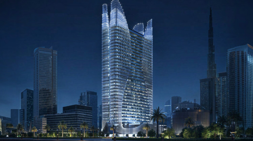 At night, a modern city skyline highlights the dazzling Binghatti Skyhall, whose undulating silhouette sparkles against a backdrop of predominantly dark buildings. Palm trees dot the foreground, while a taller, sleeker structure rises elegantly in the distance.