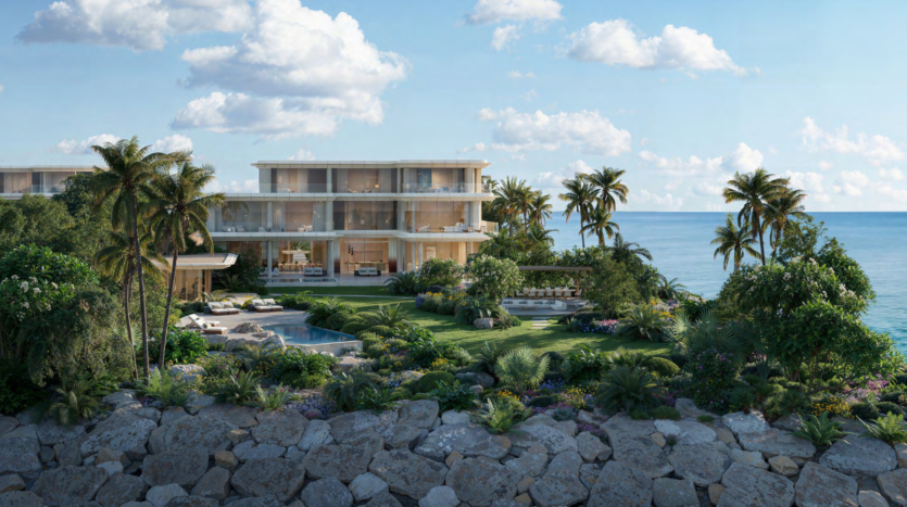 Luxurious beachfront villa in Asora Bay, Dubai, surrounded by lush vegetation and featuring large picture windows. The property features a superb pool, garden and palm trees, with stunning ocean views framed by partly cloudy skies and large rocks in the foreground.