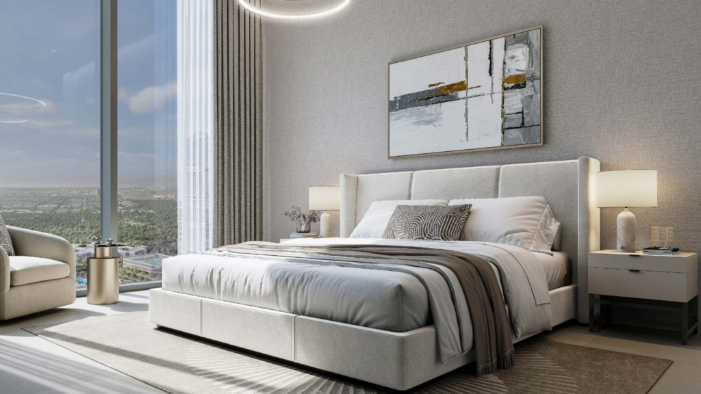 Modern room with king-size bed, neutral bedding and gray headboard. Light-colored curtains frame a floor-to-ceiling window with a breathtaking view of Skyvue. A contemporary painting and bedside tables with lamps from the Spectra collection complete the elegant decor.