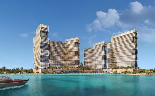Ein atemberaubender Blick auf die Strandpromenade von Damac Maritime City bringt drei moderne Wolkenkratzer mit deutlichen vertikalen Linien und begrünten Dächern zur Geltung. Im Vordergrund gleitet ein Motorboot über das türkisfarbene Wasser, während der klare Himmel nur von ein paar Wolken durchzogen ist.