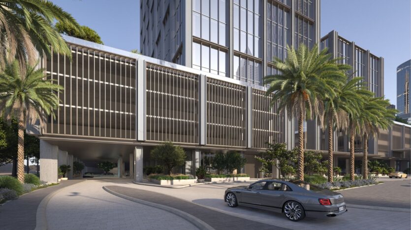 Nestled in the heart of DIFC Heights, this modern building boasts large bay windows and elegant vertical metal lines. Palm trees gently wave in front, while a silver car is parked in the driveway under a clear urban sky.