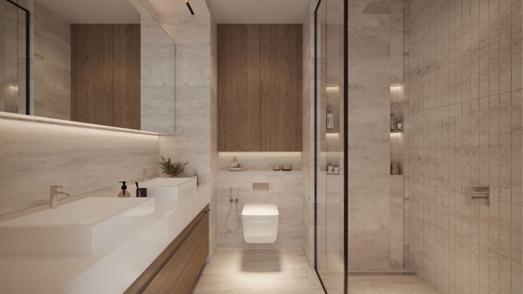 Modern bathroom in DIFC Heights, with large mirrors above a double vanity, and wood accents on drawers and walls. A wall-hung toilet adjoins a glass-enclosed shower. The room is lit by recessed spotlights, creating a warm ambience.