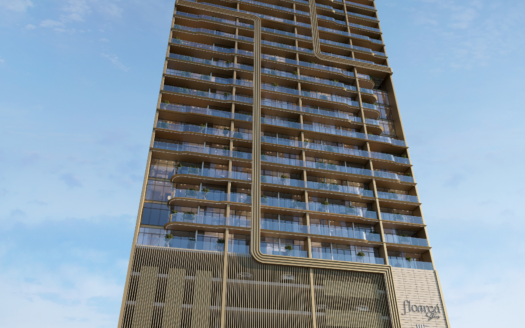 A modern high-rise building with glass balconies and distinctive vertical and horizontal lines rises against the sky of the floral zone, seen from a low angle against a blue sky with scattered clouds.