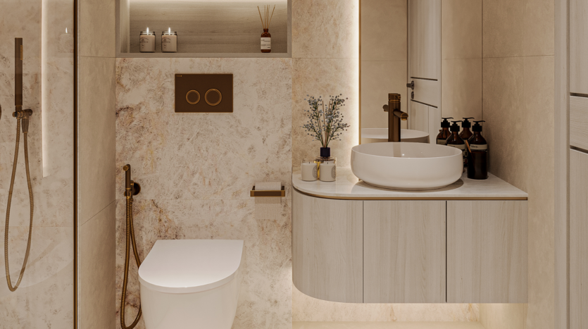 Modern bathroom with beige marble walls, wall-hung toilet, gold faucets and round washbasin on wall-hung vanity. Dark soap dispensers, small plants and floarea lighting create a warm, elegant atmosphere.