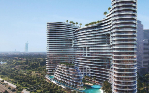 Ein moderner, geschwungener Wolkenkratzer, Binghatti Aquarise, mit Glasfassaden und grünen Dächern, steht neben einem Pool, umgeben von einer üppigen Landschaft, mit einem weit entfernten ikonischen Turm, der gegen den blauen Himmel sichtbar ist.