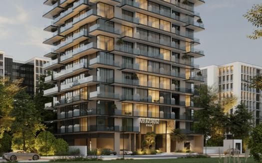Moderno edificio residencial de varias plantas con grandes balcones acristalados, rodeado de árboles y vegetación, situado en el Arlington Park de Dubai. El interior está bañado por una luz cálida, con algunos coches aparcados delante y los edificios adyacentes visibles al fondo.