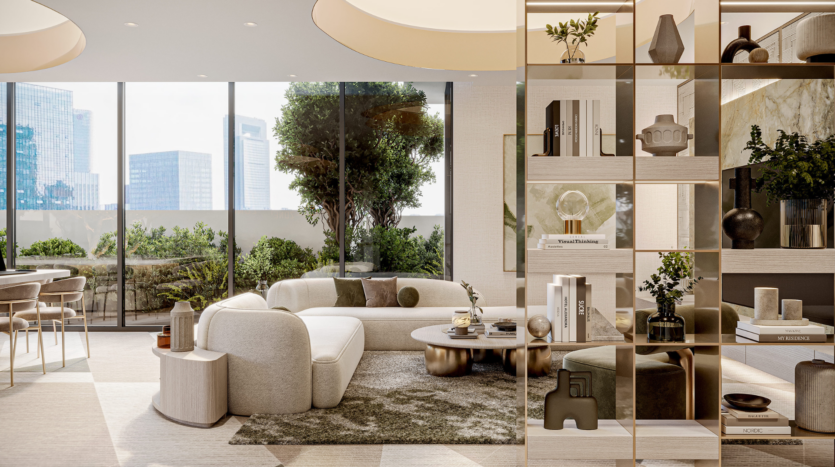 Un salon moderne à Arlington Park, Dubaï, dispose d'un canapé blanc incurvé, d'une table basse ronde, d'étagères décoratives, de grandes fenêtres avec vue sur la ville et d'un espace vert. Lumineux, spacieux, il est élégamment décoré de livres et de vases.