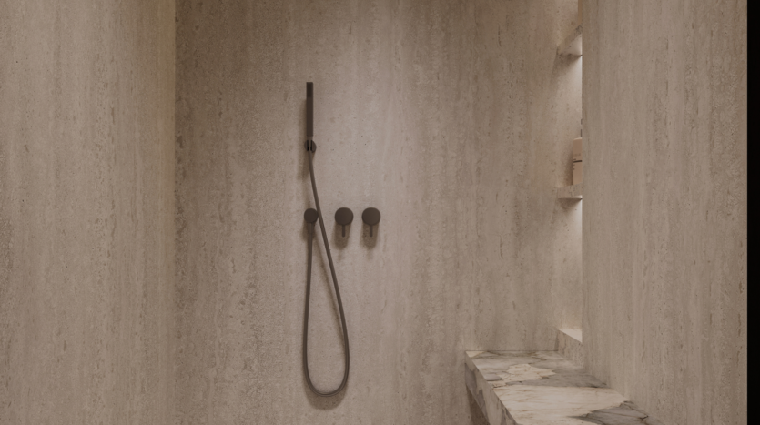 A minimalist shower with beige textured walls, an elegant black showerhead, three matching round control knobs, a built-in shelf containing toiletries and a marble-covered bench.