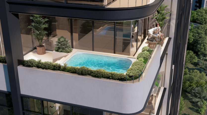 A modern apartment balcony at Provenza Residences Dubai features a small pool, glass balustrades, potted plants and a person sitting on a chair near the edge, surrounded by greenery and overlooking trees.
