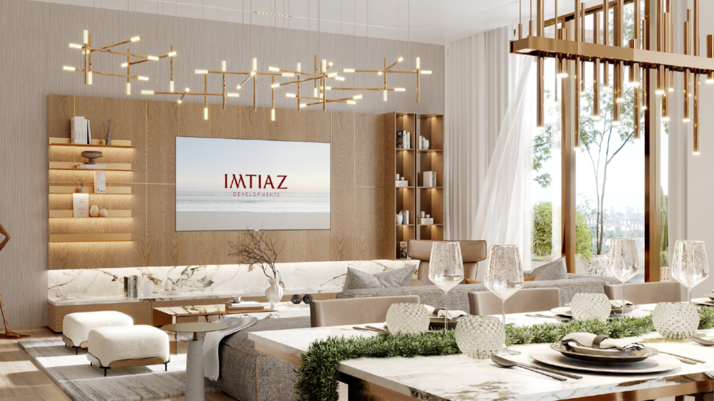 Soggiorni e sale da pranzo eleganti e moderni con toni neutri, ampie finestre, superfici in marmo, lampadari contemporanei e una TV a parete con la scritta "IMTIAZ": l'ambiente perfetto per godersi il lusso ispirato all'isola del Wynnwood Dubai.
