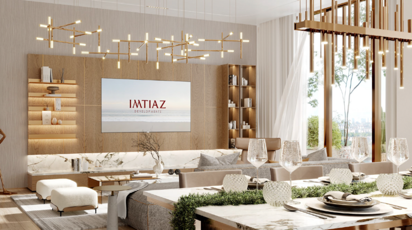 Soggiorni e sale da pranzo eleganti e moderni con toni neutri, ampie finestre, superfici in marmo, lampadari contemporanei e una TV a parete con la scritta "IMTIAZ": l'ambiente perfetto per godersi il lusso ispirato all'isola del Wynnwood Dubai.