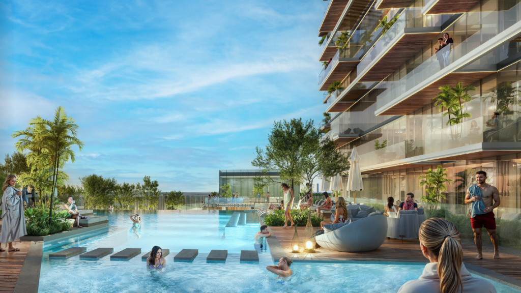 Die Besucher entspannen und baden in einem modernen Außenpool, der von Grünflächen und einem Gebäude mit Luxusappartements mit Balkonen umgeben ist. Der klare, blaue Himmel schafft eine vibrierende und einladende Atmosphäre.