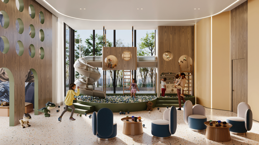 Modern indoor playroom with climbing structures, large spiral slide, ball pool and children's games. Large windows let in natural light; round tables and soft armchairs are arranged in the foreground. Trees can be seen outside.