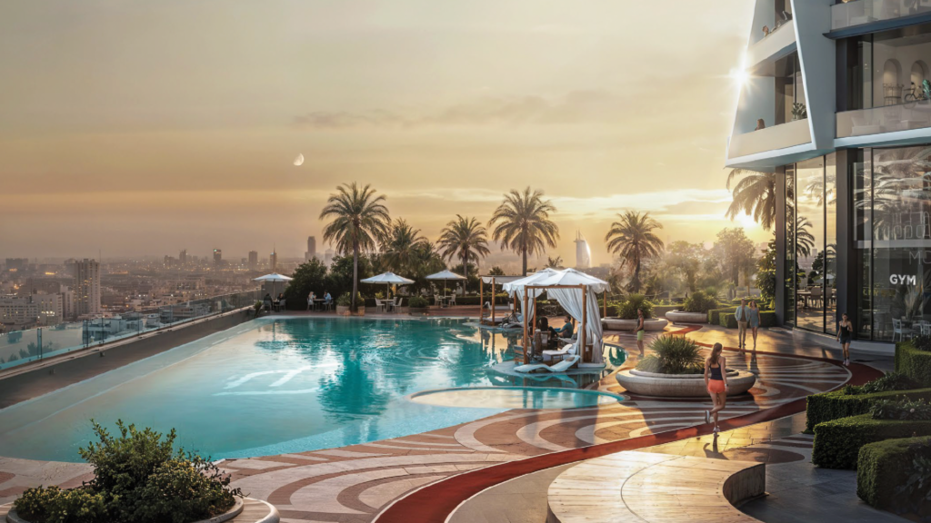 A luxurious rooftop pool at sunset, with palm trees, cabanas, sun loungers and a view of the city skyline. One person strolls by the pool, while others relax under white awnings. The scene exudes relaxation and elegance.