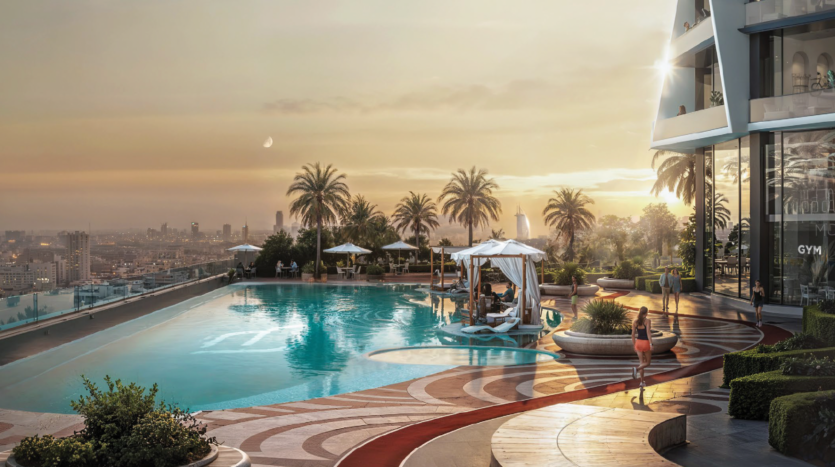 A luxurious rooftop pool at sunset, with palm trees, cabanas, sun loungers and a view of the city skyline. One person strolls by the pool, while others relax under white awnings. The scene exudes relaxation and elegance.
