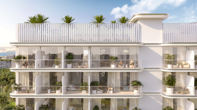 Immeuble moderne de plusieurs étages avec de grands balcons en verre, des plantes vertes luxuriantes et des sièges extérieurs. Le jardin sur le toit avec des palmiers donne à la Cove Edition 6 de Imtiaz un air de station balnéaire par une journée ensoleillée avec un ciel bleu et des nuages.