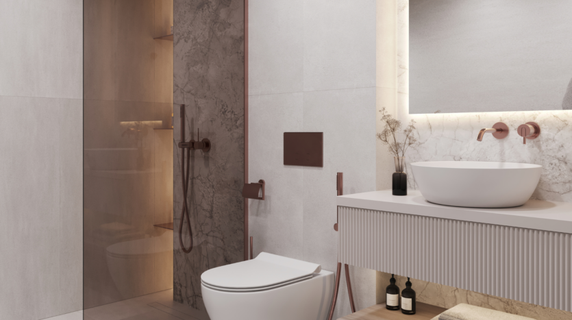 Salle de bains moderne avec toilettes murales, lavabo rond sur meuble blanc, décor minimaliste, étagères encastrées et douche vitrée aux finitions beige et marbre. L'éclairage chaleureux met en valeur le design épuré et élégant.