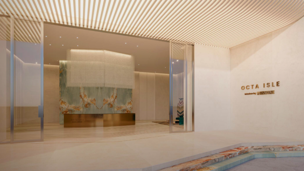 Minimalist, modern lobby with a large decorative chandelier, abstract wall art, elegant reception counter and "OCTA ISLE" and "JLL RESI" signs on the wall near the glass entrance doors.
