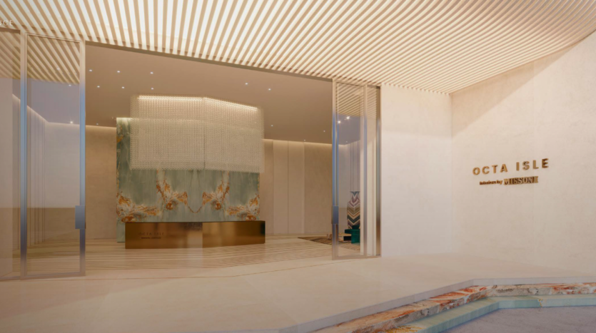 A modern, elegant lobby with cream-colored walls, a large abstract artwork behind the reception counter, glass doors and signage reading "OCTA ISLE Residences by LIFESTYLE" on the right wall, reflecting the essence of Dubai's Octa Isle.