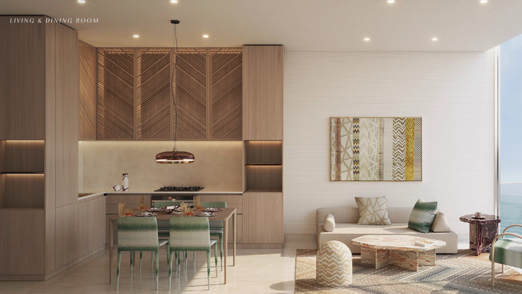 A modern, open-plan living and dining room features a wooden kitchen with herringbone-patterned cabinets, a dining table with green chairs, a cozy sitting area, patterned decor and large windows with ocean views.