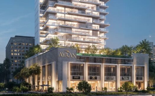 Ayaan Heights 1 by IGO is a modern multi-storey building christened "Ayaan", featuring stores on the lower floors and a tower above with balconies and greenery, beautifully illuminated at night.