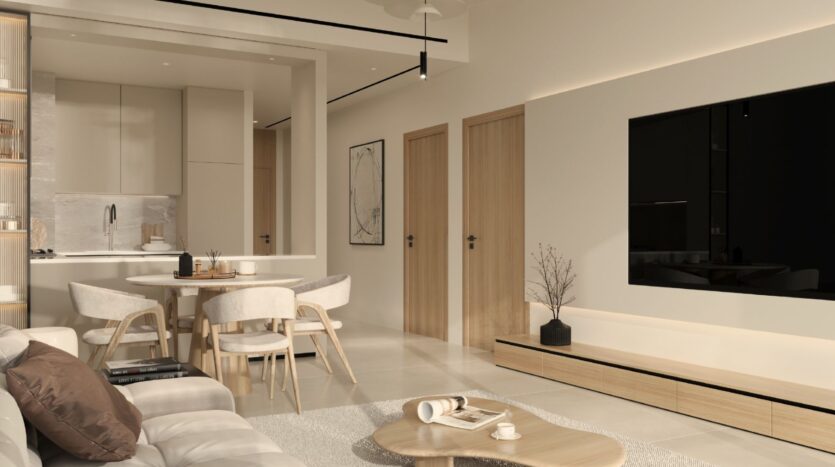 Modern, minimalist living and dining room in Ayaan Heights 1 by IGO, with beige and neutral tones, light wood furniture, a round dining table with four chairs, a wall-mounted TV, a coffee table on a rug, and a kitchen visible in the background.