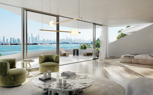 Modernes, offenes Schlafzimmer und Wohnbereich mit Fenstern, die vom Boden bis zur Decke reichen und auf die Skyline der Stadt und die Strandpromenade blicken. Es umfasst zwei grüne Stühle, einen Marmor-Couchtisch und ein Bett in der Nähe eines großen Balkons.