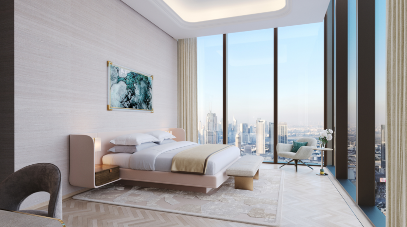 Camera moderna del Waldorf Astoria Business Bay Dubai con letto king, panca, opere d'arte astratta alle pareti e finestre a tutta altezza che offrono una vista mozzafiato sullo skyline della città. Le decorazioni leggere e la poltrona da lettura creano un'atmosfera lussuosa e ariosa.