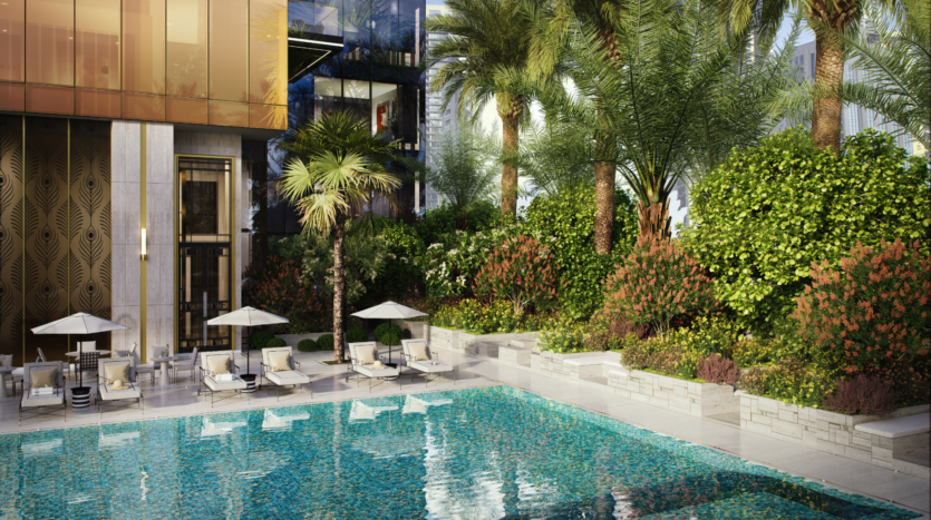 Lussuosa piscina all'aperto del Waldorf Astoria Business Bay Dubai, circondata da palme e arbusti verdi, con lettini e ombrelloni bianchi a bordo piscina accanto alla facciata di un edificio moderno.