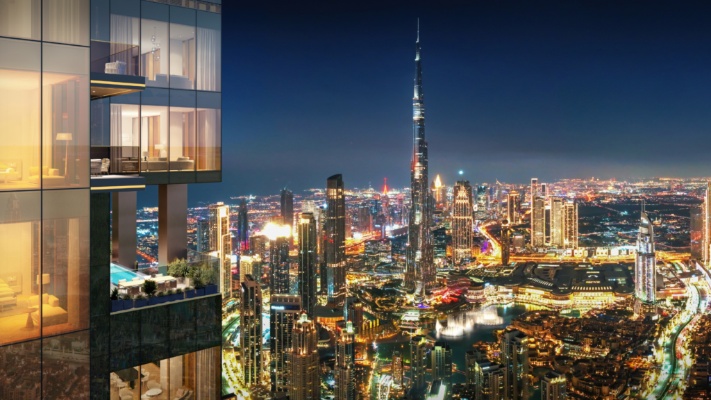 Una moderna torre residenziale con balconi e piscina si affaccia sullo skyline di Dubai illuminato di notte, con il Burj Khalifa ben visibile tra gli altri grattacieli.