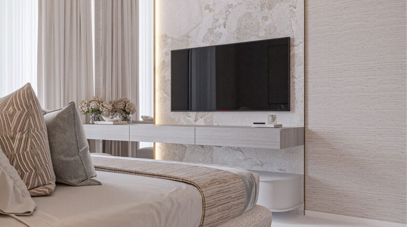 Chambre à coucher moderne composée d'un lit bien fait, de coussins décoratifs belle vie zimaya, d'une télévision murale, d'une console flottante minimaliste, de tons neutres et d'une lumière naturelle douce provenant de hautes fenêtres aux rideaux diaphanes.