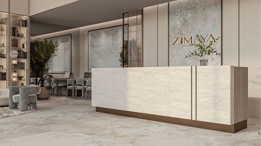 Une réception moderne avec un bureau en marbre, un décor minimaliste, des tons neutres, des plantes en pot, des sièges élégants et un panneau mural sur lequel on peut lire "Belle Vie Zimaya Properties".