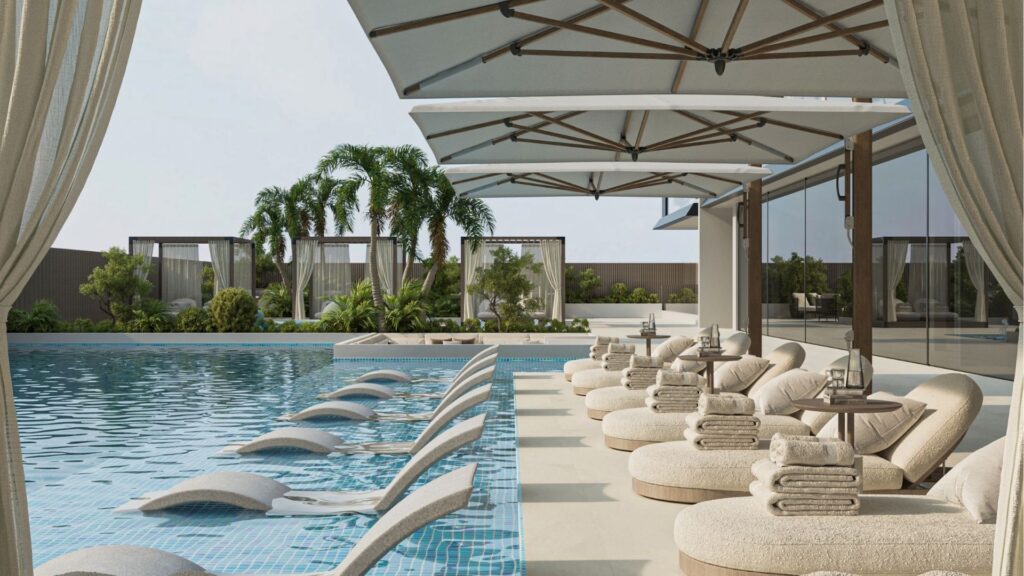 La piscine luxueuse est équipée de chaises longues dans l'eau, de chaises longues rondes avec serviettes, de grands parasols et de cabanons - style Belle Vie Zimaya - entourés de palmiers tropicaux pour une atmosphère vraiment relaxante.