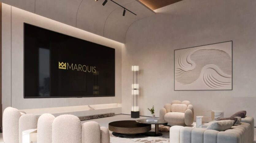 Marquis One Arjan's sleek, modern living room features cream-colored curved sofas, a round table, tall floor lamps, a large black screen displaying "MARQUIS" and abstract wave-patterned wall art. The space is lightly lit.