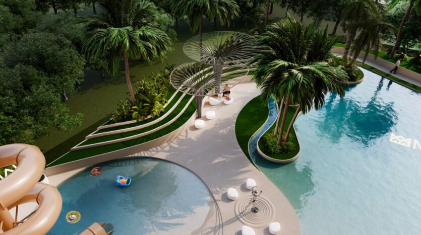 Aerial view of the Marquis One Arjan outdoor pool, featuring a curved pool, palm trees, sun loungers, sculptural shade structures and a waterslide, all surrounded by lush greenery.