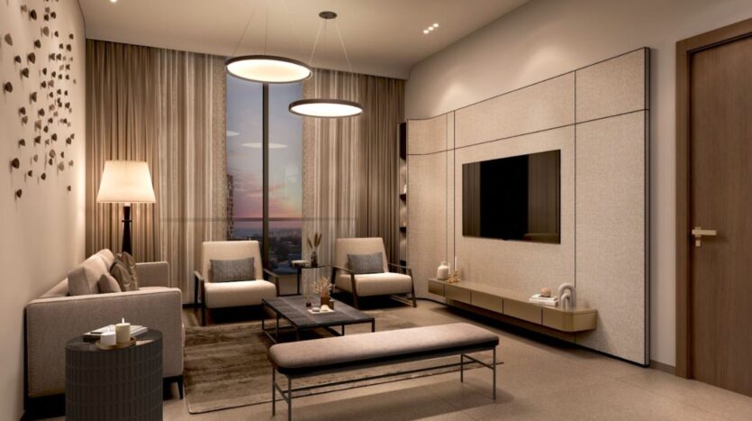 Marquis One Arjan's modern living room features beige walls, a large window with curtains, neutral sofas and armchairs, a wall-mounted TV, floor lamp, bench and coffee table, all illuminated by elegant decorative elements.