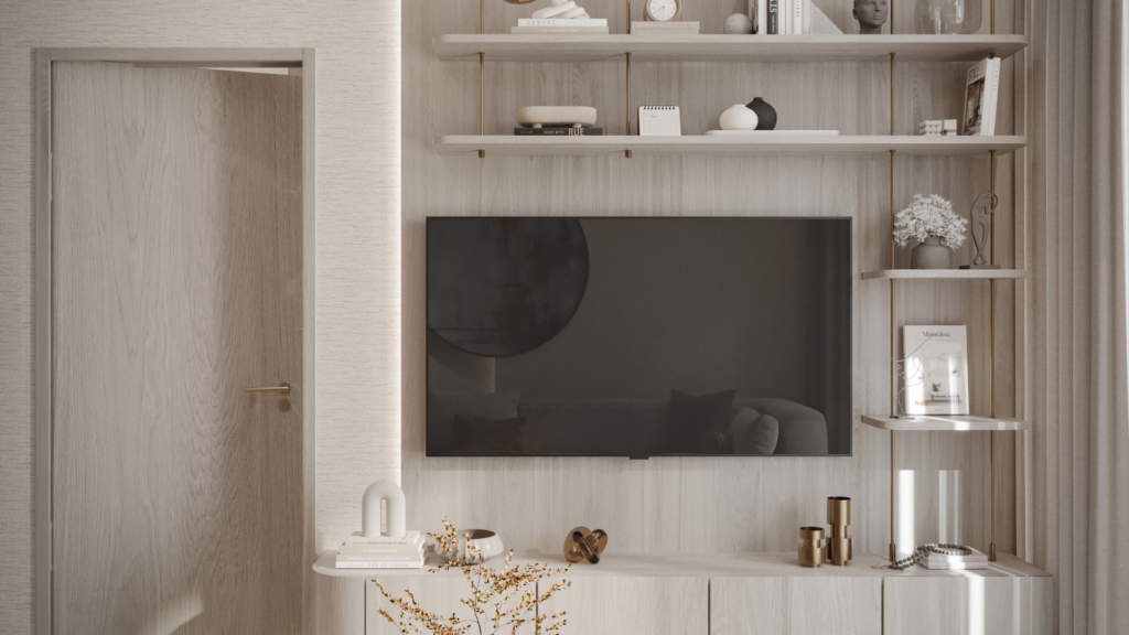 Sala de estar moderna con muebles de madera clara, un televisor montado en la pared, estanterías decorativas con libros, jarrones y chucherías, y una puerta de madera parcialmente abierta a la izquierda. Colores cálidos y neutros.