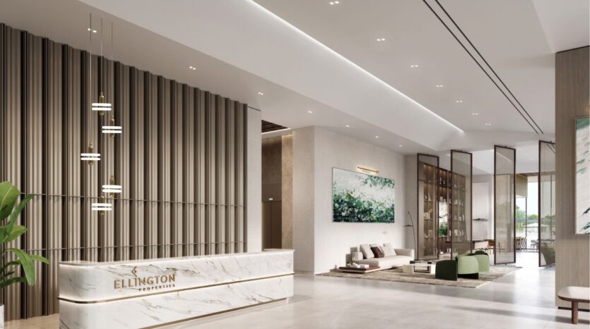 The modern lobby of Riverton House by Ellington Properties features a marble reception, vertical paneling, pendant lights, elegant green-accented seating, large artwork and floor-to-ceiling windows.