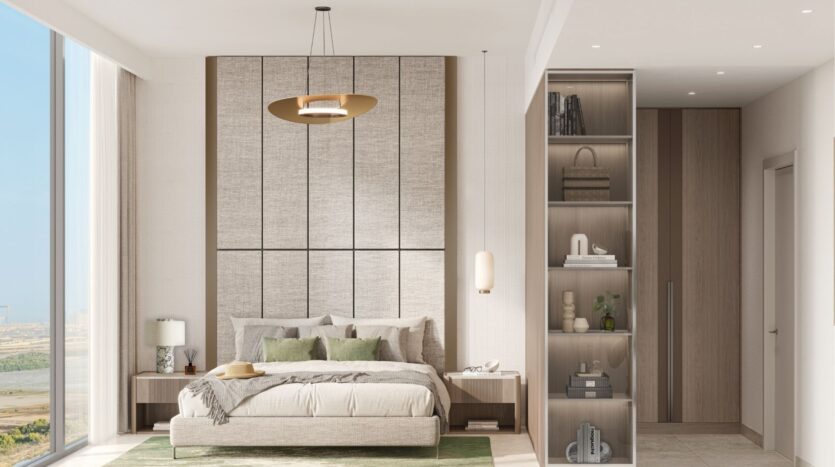 Modern bedroom at Riverton House by Ellington Properties with king-size bed, green accents, bedside tables and pendant lamp. Floor-to-ceiling windows offer city views, while open shelving and neutral tones create a sleek, sophisticated look.