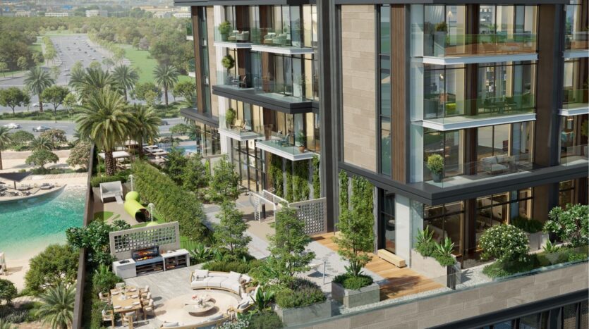A modern apartment building with large bay windows and spacious balconies, Riverton House by Ellington Properties features lush greenery, an outdoor area with a fireplace, a slide and a pool surrounded by trees close to a road and park.