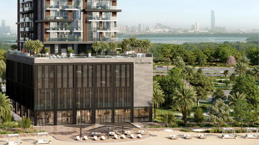 Modern high-rise building with "Ellington" sign, palm trees, rooftop terrace and lounge area to the front; cityscape and greenery in the background. Experience upscale living at Riverton House by Ellington Properties.