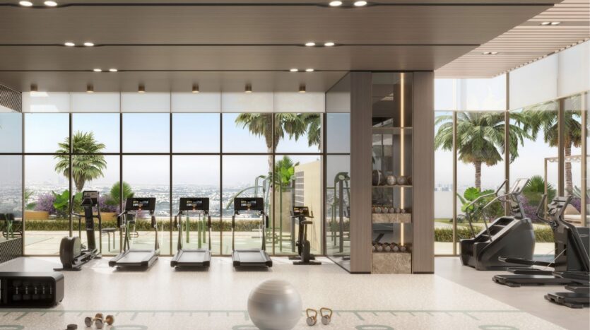 Modern gym at Riverton House by Ellington Properties with floor-to-ceiling windows, multiple treadmills, weight racks and fitness equipment. Enjoy palm trees and city views through the large picture windows.