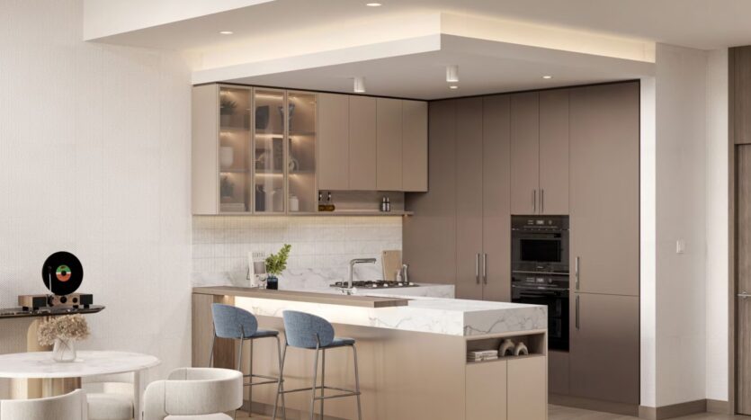 Cuisine moderne à Windsor House de Ellington Properties avec des armoires beiges, des appareils encastrés, des comptoirs en marbre, un petit îlot avec des tabourets de bar bleus, des étagères ouvertes pour les plantes et la décoration, ainsi qu'une table de salle à manger et un tourne-disque au premier plan.